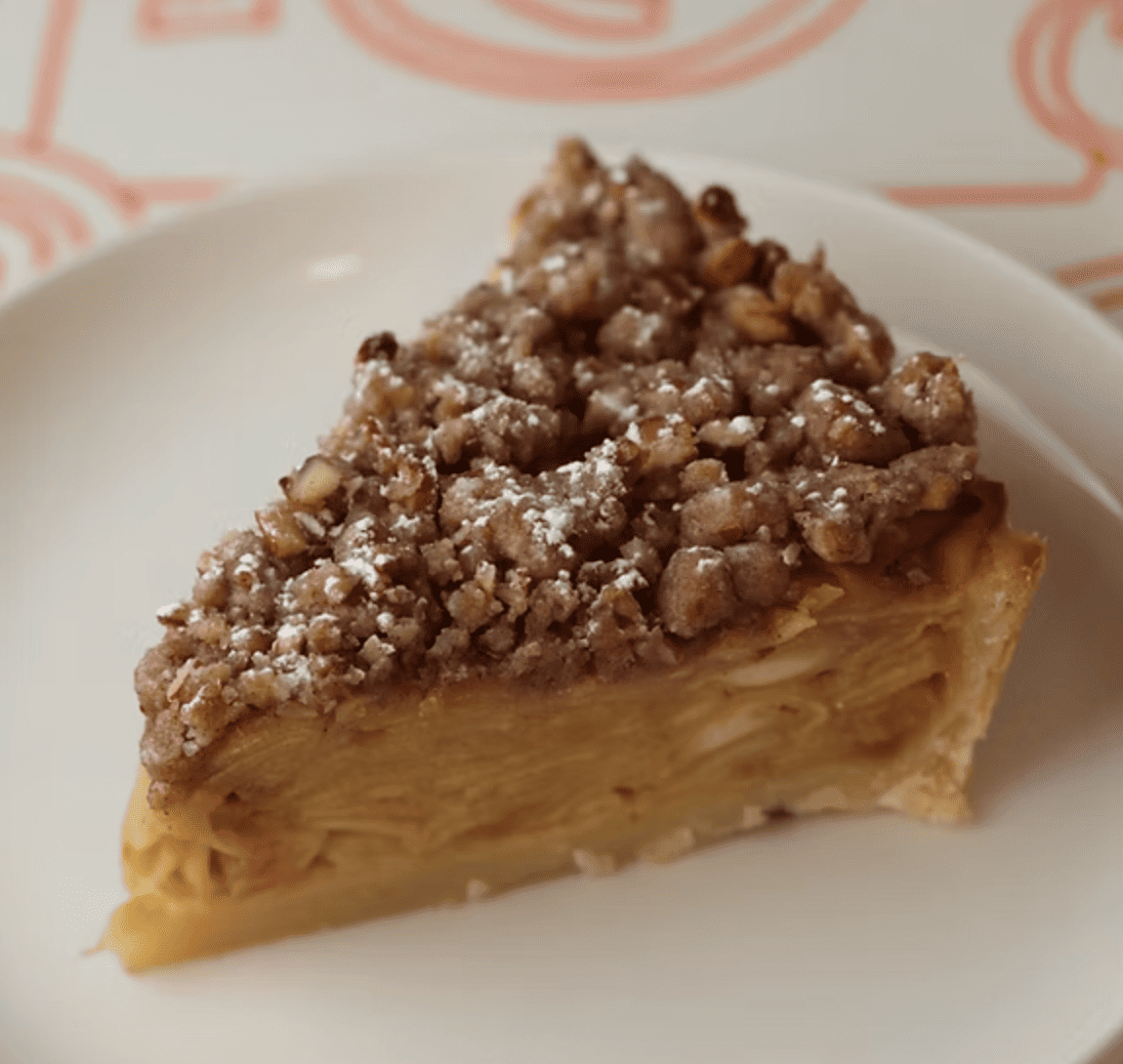 Postre de manzana horneada con cobertura crujiente de avena y azúcar moreno.