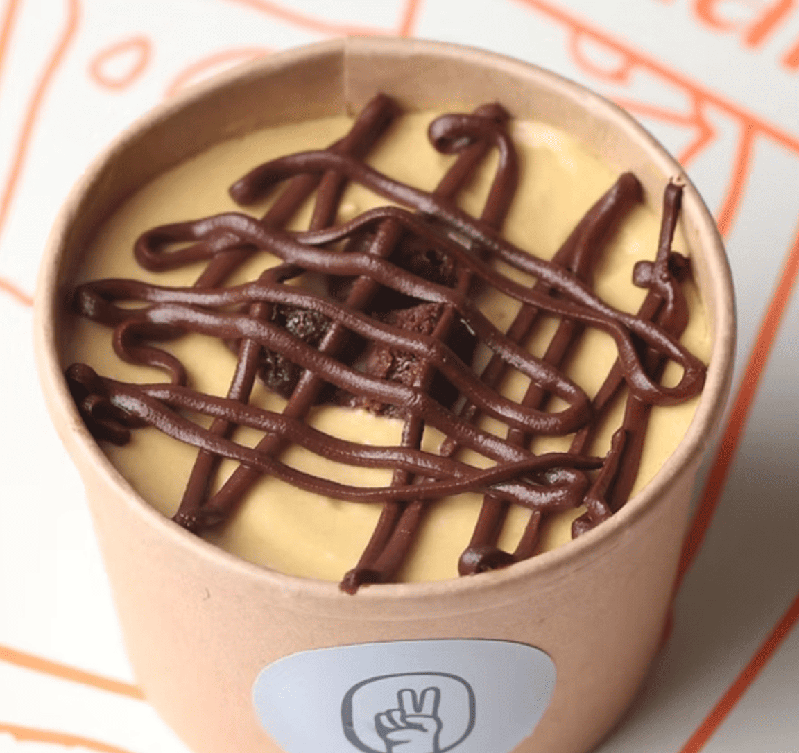 Tarrina de postre cremoso de lúcuma y chocolate, combinación de sabores peruanos.