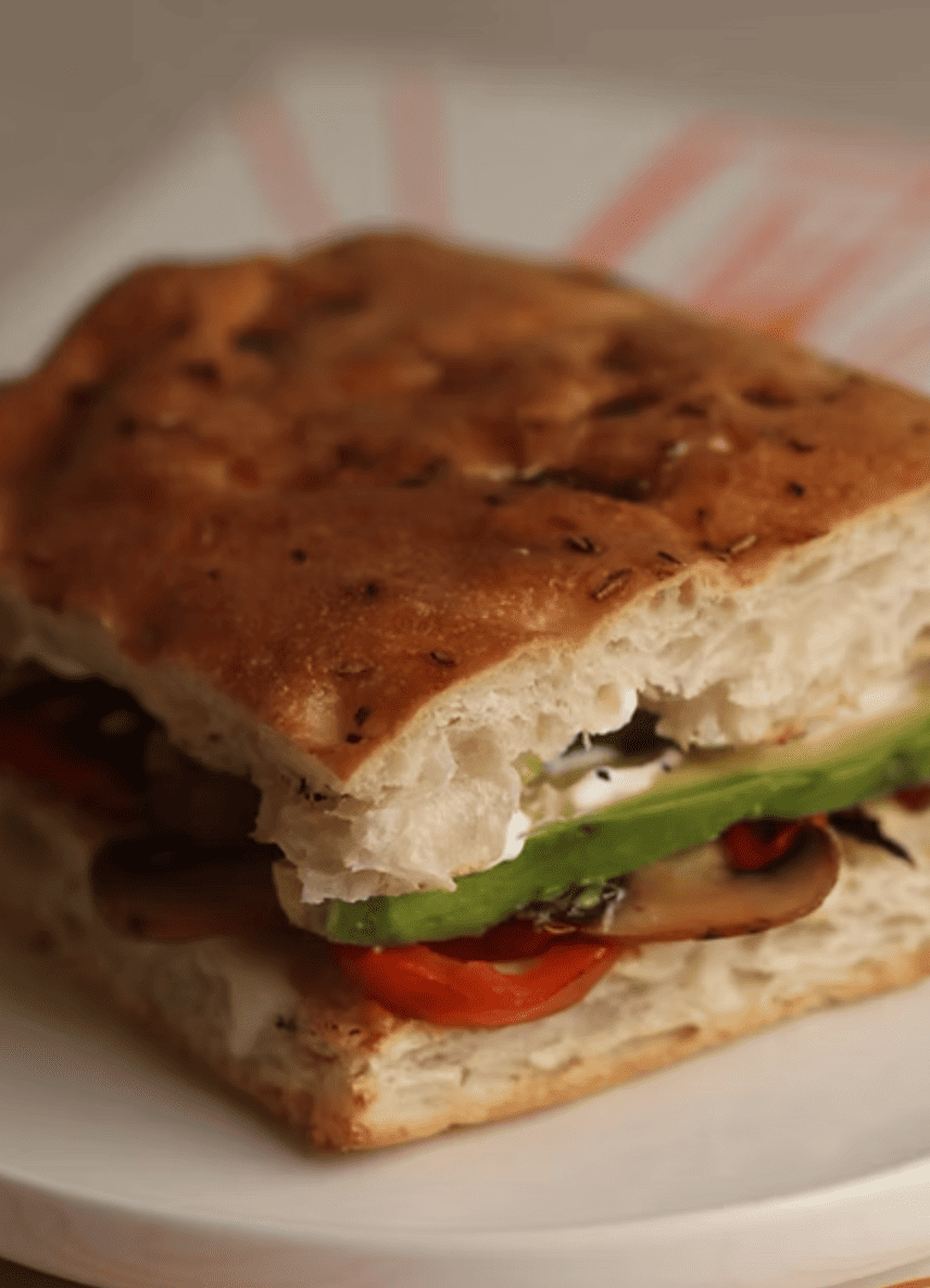 Sánguche de focaccia con jamón, queso derretido y mantequilla de hierbas.