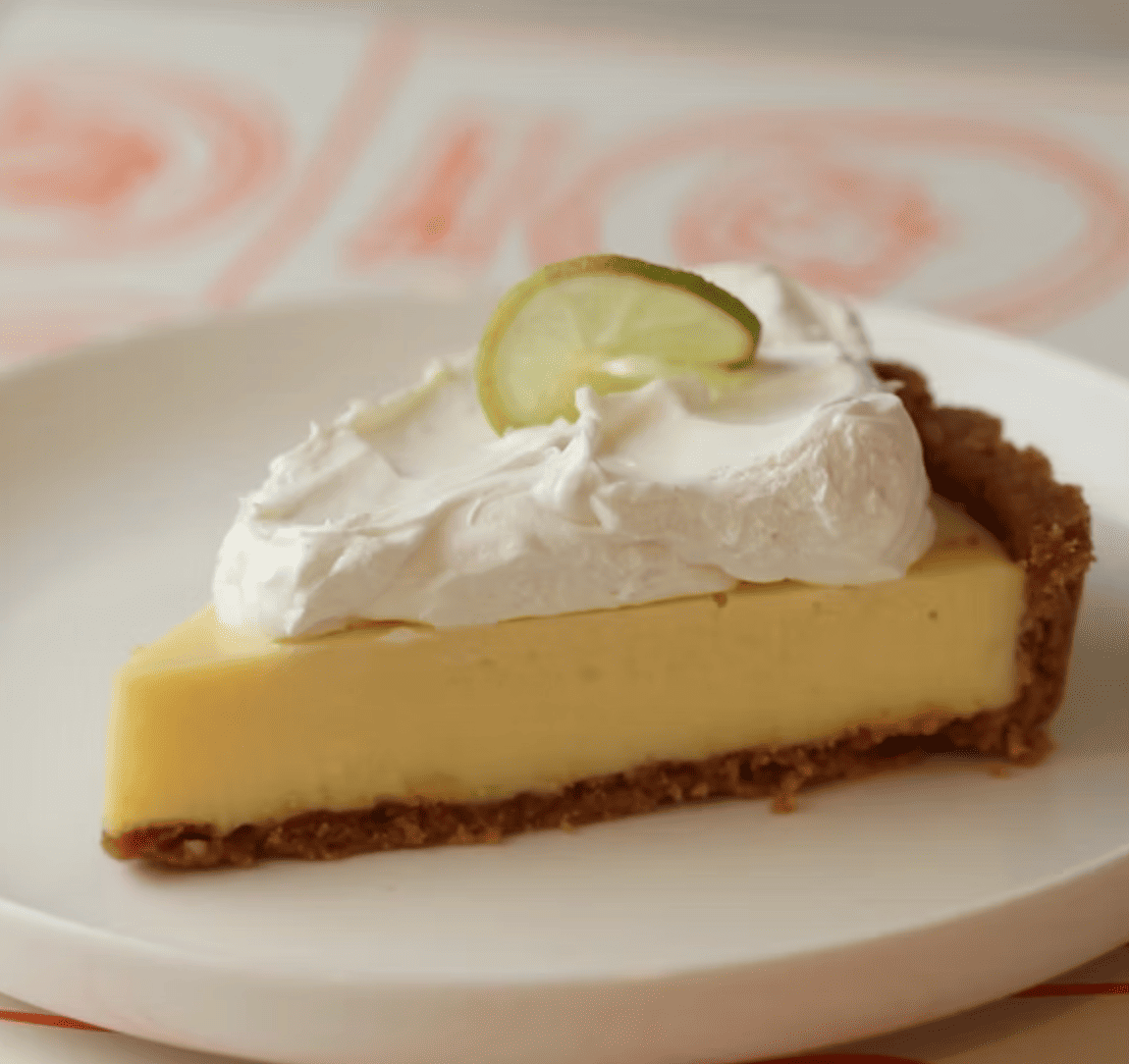 Trozo de pie de limón con base de galleta y merengue dorado.