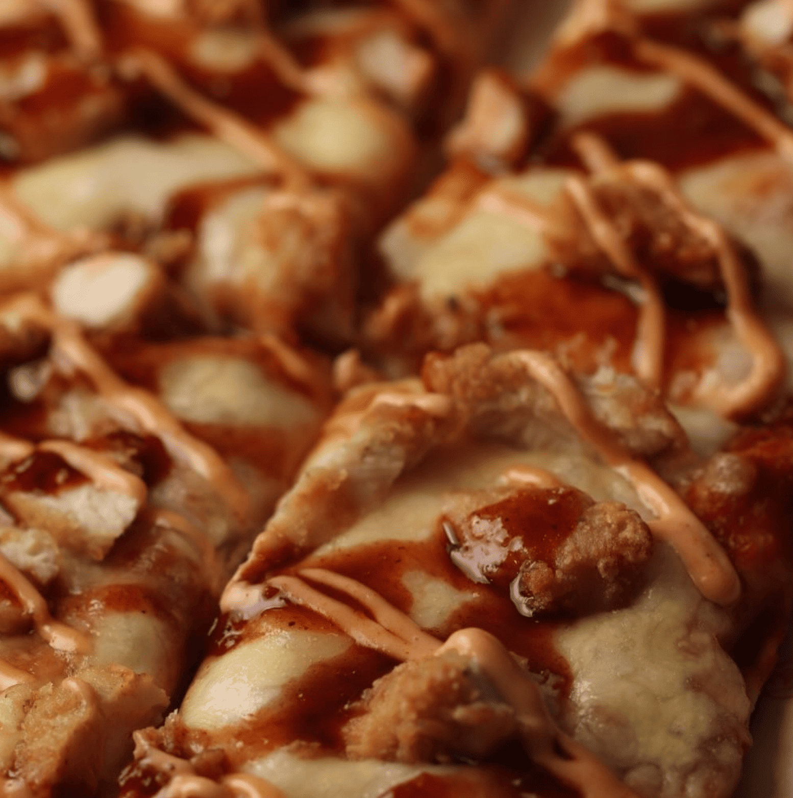 Pizza con pollo crispy, salsa barbacoa, queso derretido y salsa especial 2080.